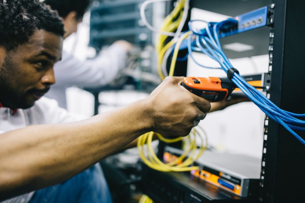 A data center engineer works to install new cabling for a rack that could be located in a new edge network for an organization trying to reach end users and clients closer to where they physically reside. Learn how to build an edge network and what to consider in edge computing solutions.