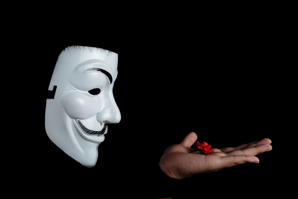 A photo showing black background with a floating Guy Fawkes mask and a hand with what appears to be a small rose as this article is about the advanced threat of ransomware, the dangerous malware strain holding data hostage at a steep price. Learn more about the top ransomware protection tools, solutions, and vendors.